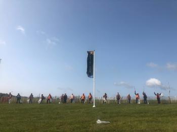 Lineup Of Litter Pickers With Flag In The Middle