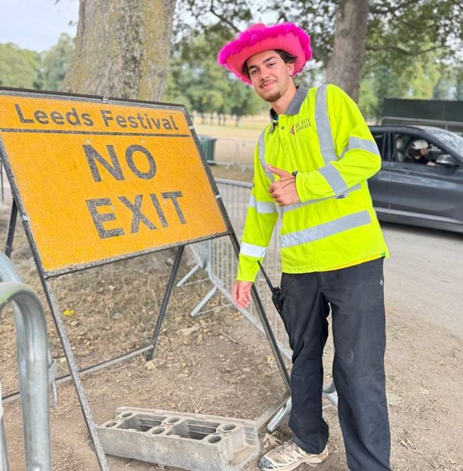 Crew Member By No Exit Sign Wearing Hat