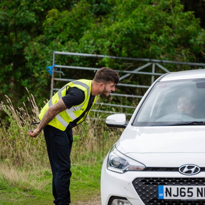 leaning in to speak to car.png