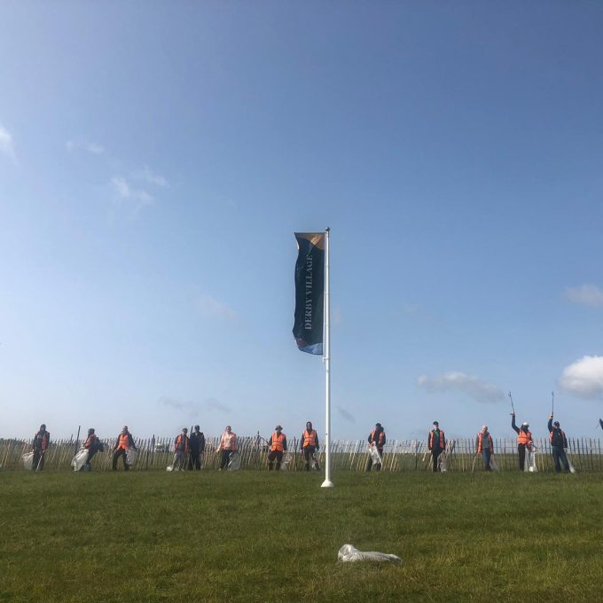 Lineup Of Litter Pickers With Flag In The Middle